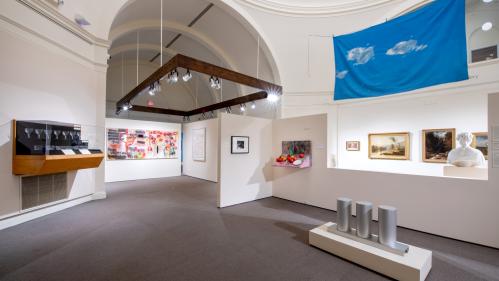 Installation view of American gallery with paintings and sculpture on walls and hanging from ceiling