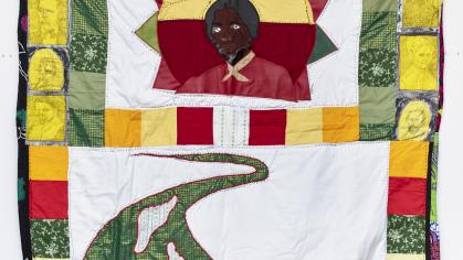 Quilt with image of Harriet Tubman and a green path with white and black footsteps, surrounded by images of other abolitionists.