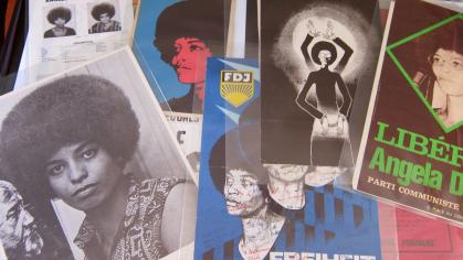 Photo of posters related to Angela Davis spread on a table