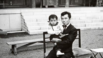 Black and white snapshot of an Asian man holding a baby