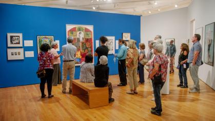 people standing in gallery looking at art