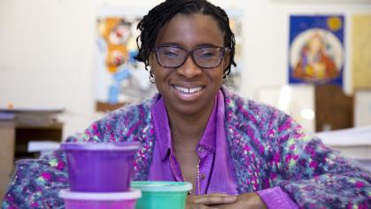photo of African American woman with glasses wearing a purple jacket