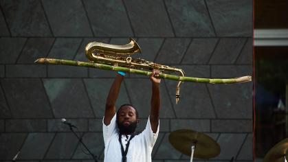 Jerome Ellis holds instruments above their head on stage.