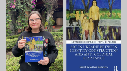 Gray background with two images next to each other. Left image is of the author, a woman with brown hair, glasses, and a black cardigan standing in front of greenery while holding a book. The right image is a book cover featuring artwork of children standing in a line all dressed in yellow.
