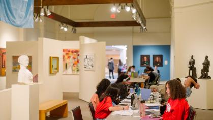 Students studying at tables in the American art gallery