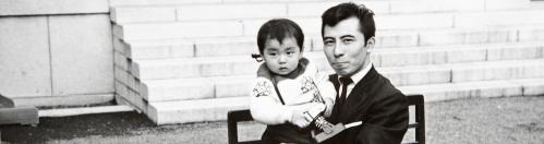 Black and white snapshot of an Asian man holding a baby