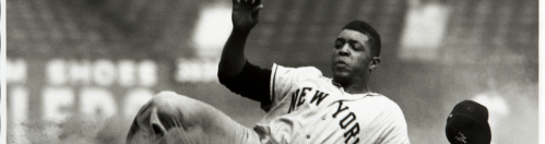 Baseball player, Willie Mays, slides into a base.