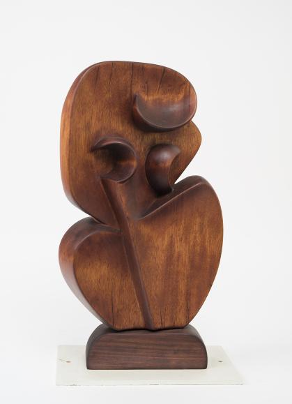 Carved wooden sculpture of two curved shapes reminiscent of a violin shape with 3 raised curvilinear shapes on the top shape