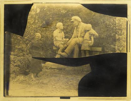 Photo from broken, incomplete negative of woman standing before an outdoor sculpture