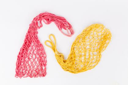 Two mesh net bags; one is pink, one is yellow