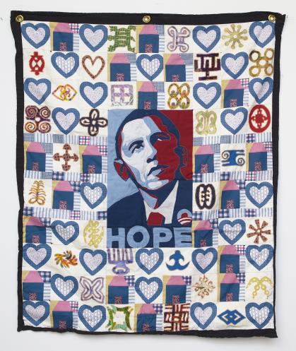 Quilt with central panel of Barack Obama with text underneath reading HOPE, surrounded by hearts and adrinka symbols from Ghana. 