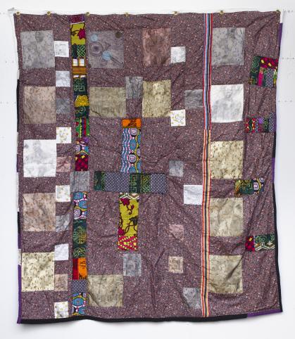 Irregular multicolored quilt with blocks with photographs of musicians printed on light fabric