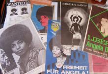 Photo of posters related to Angela Davis spread on a table