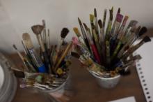 dirty paintbrushes standing in cups