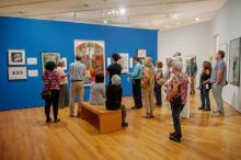 people standing in gallery looking at art