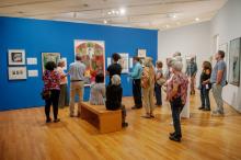 people standing in gallery looking at art