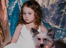 young girl in dress holding small dog