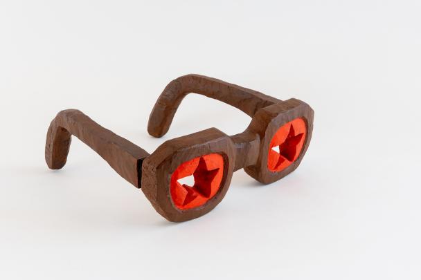 Carved glasses made from wood with each "lens" painted red with a star shape cut-out