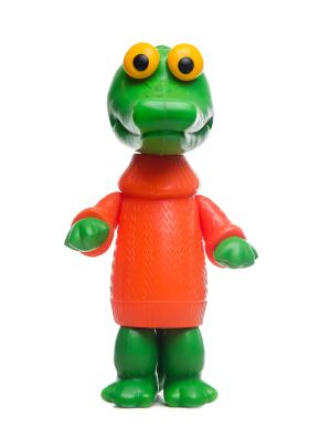 Plastic toy of standing crocodile with yellow eyes, dressed in red sweater