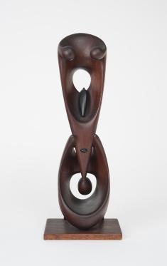 Dark wooden carved sculpture with triangular form on top of oval form. Both forms have holes. 