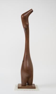 Wooden carved abstract sculpture reminiscent of a figure with a long torso and neck. 